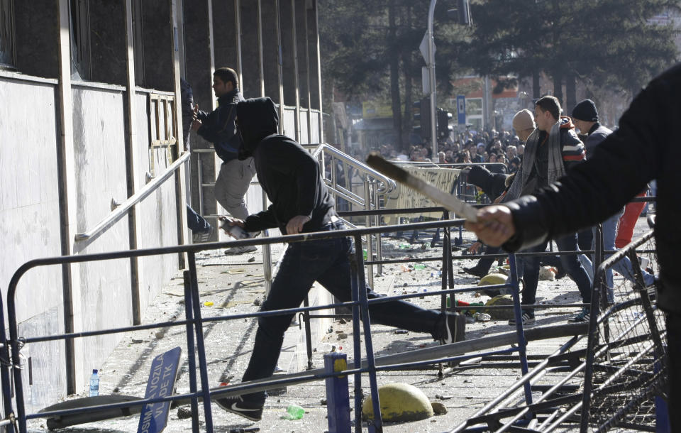 Bosnian protesters run towards a local government building, during a protest, in the Bosnian town of Tuzla, Friday, Feb. 7, 2014. Bosnian protesters stormed and set ablaze local government buildings in three Bosnian cities on Friday in fury over unemployment and rampant corruption. At least 90 people were injured. (AP Photo/Amel Emric)