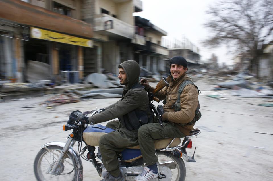 Fighters of the Kurdish People's Protection Units (YPG) patrol on a motorcycle in the streets of the northern Syrian town of Kobani