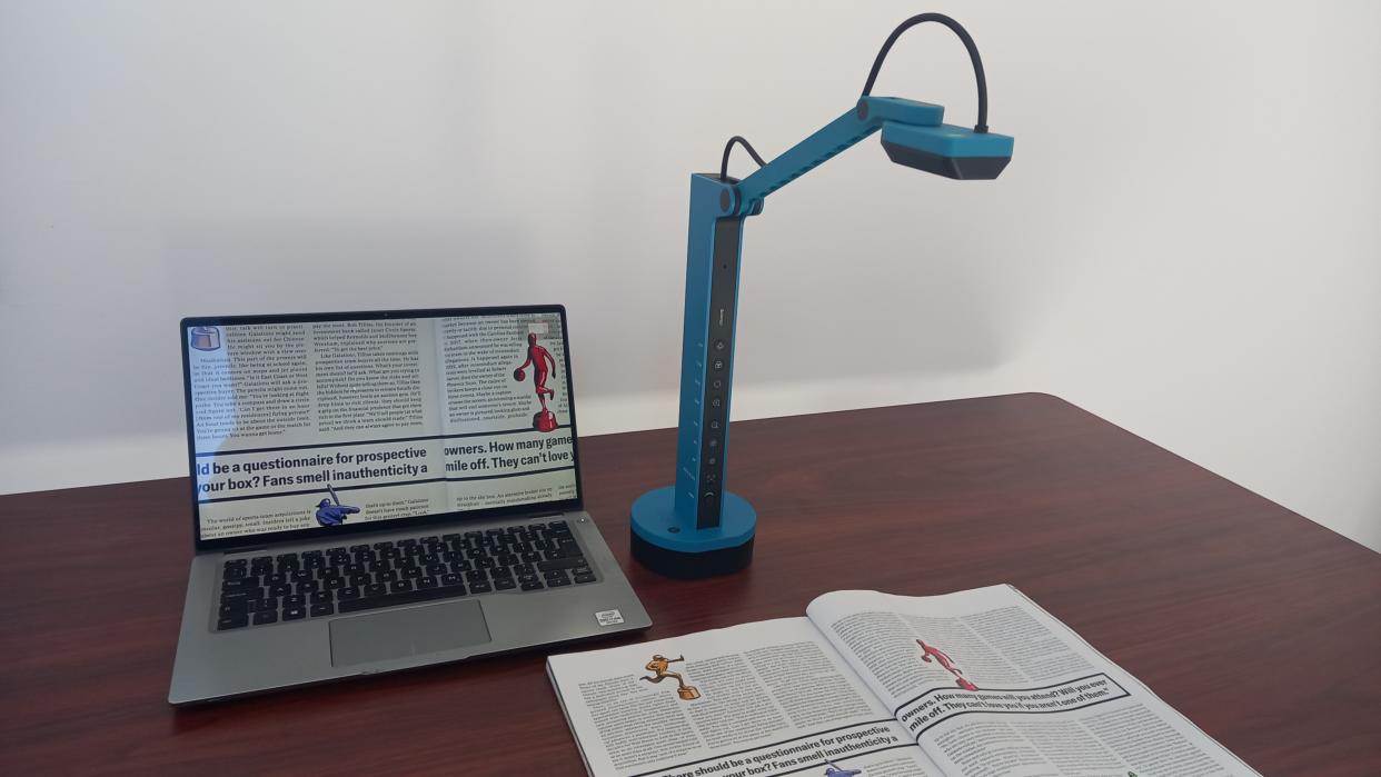  Ipevo VZ-X document camera on desk scanning book and the image appearing on a laptop. 