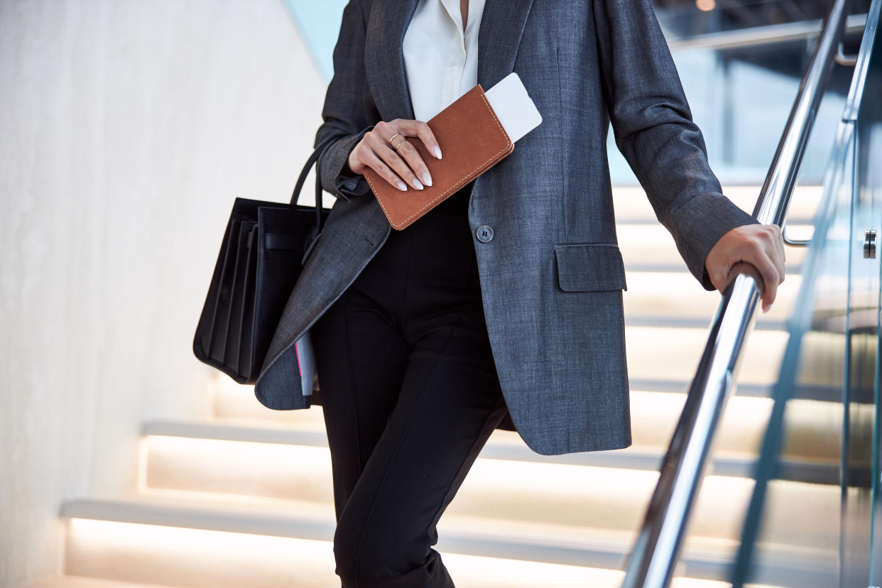 Close up of elegant woman with airplane ticket and passport holder