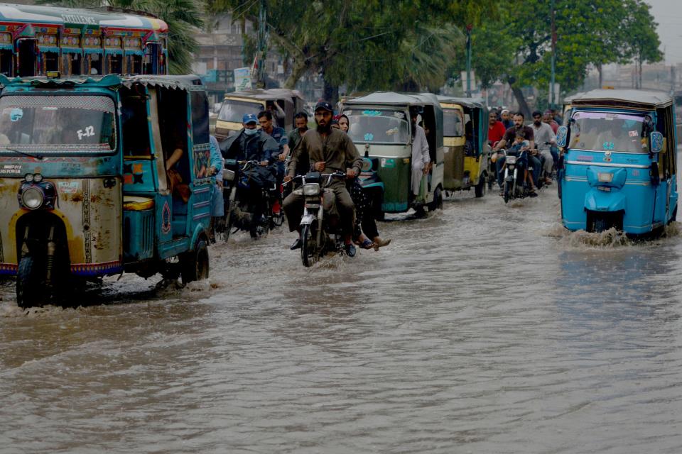 Motorists make their way through a flooded street in Karachi