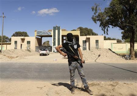 A militia stands guard in front of the entrance to the February 17 militia camp after Libyan irregular forces clashed with them in the eastern city of Benghazi May 16, 2014. REUTERS/Esam Omran Al-Fetori