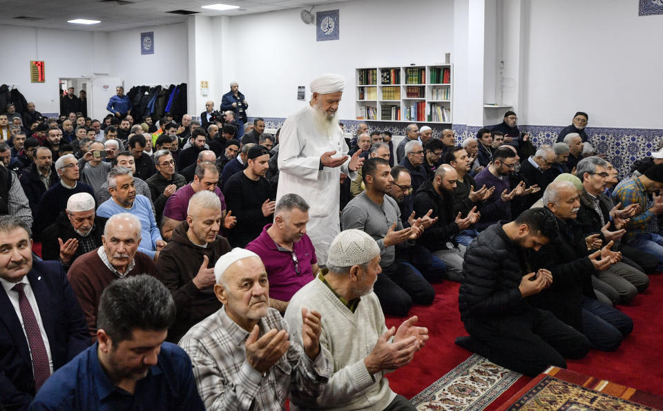 Muslim believers pray in a mosque for the victims of the shooting in Hanau, Germany, Friday, Feb. 21, 2020. A 43-year-old German man shot and killed several people of foreign background, most of them Turkish, on Wednesday night in an attack that began at a hookah bars. (AP Photo/Martin Meissner)