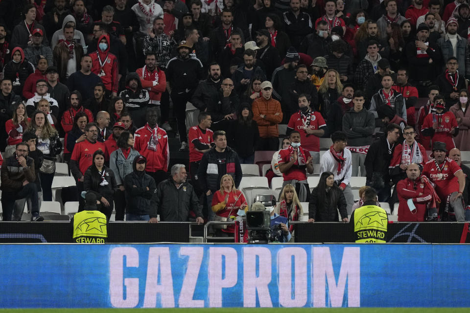 Advertisement of the Russian state-owned gas company Gazprom displayed on an advertising board as Benfica fans attend the second half of the Champions League round of 16, first leg, soccer match between Benfica and Ajax at the Luz stadium in Lisbon, Wednesday, Feb. 23, 2022. (AP Photo/Armando Franca)