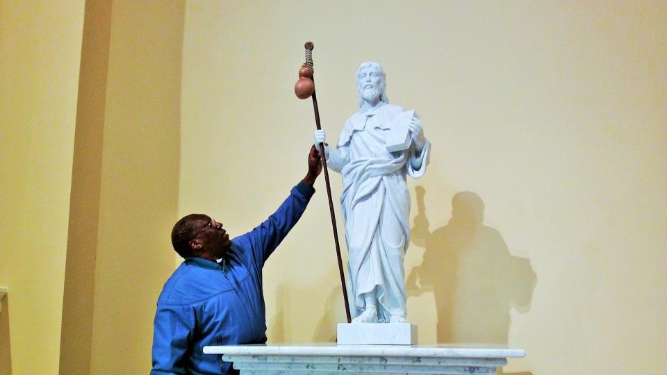 Father Charles Opodo-Owora checks out the new St. James statue in the renovated church.