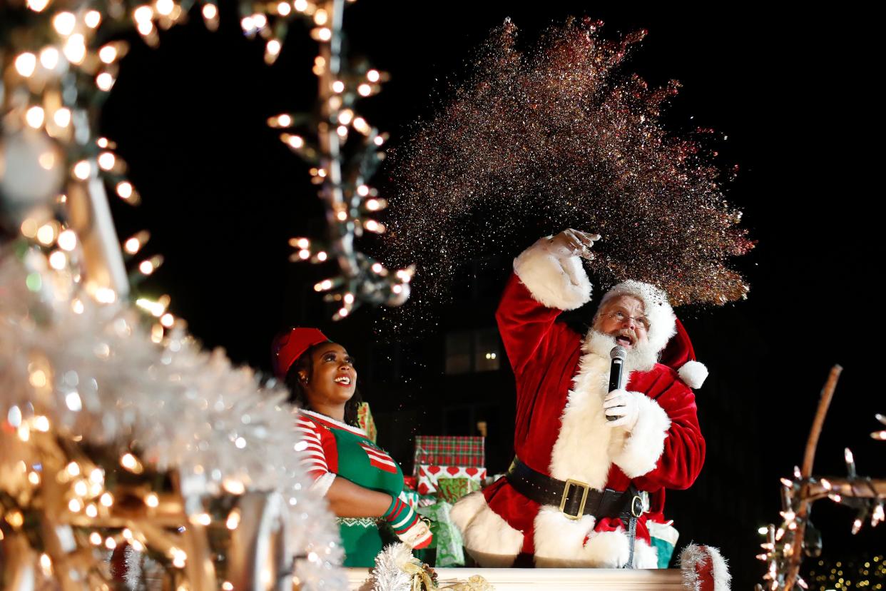 FILE - Santa Claus throws the magic dust to light the Athens community Christmas tree during the Downtown Parade of Lights in downtown Athens, Ga., on Thursday, Dec. 1, 2022.