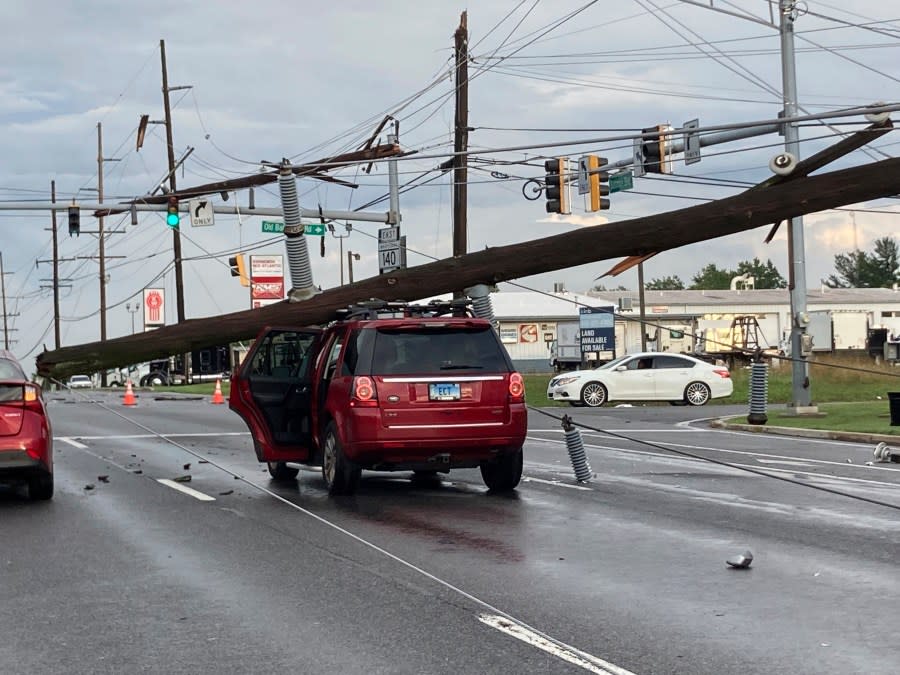 A fallen pole rests on a car at the intersection of Route 140 and Market Street in Westminster., Md., on Monday, Aug. 7, 2023. (Baltimore Sun Staff/The Baltimore Sun via AP)