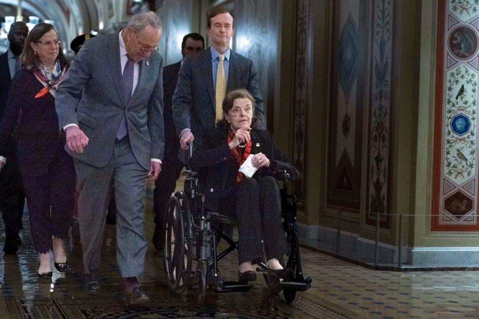 范士丹今年飽受病痛之苦，圖為2023年5月10日坐輪椅前往國會大廈，參院多數黨領袖舒默（Chuck Schumer）走在她身邊。美聯社