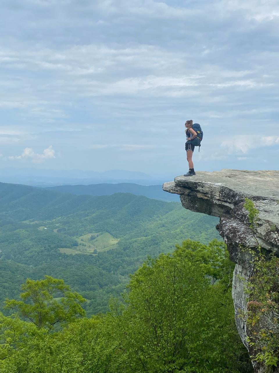 Poughkeepsie native Alexis Holzmann is photographed by a hiking partner atop the summit of a mountain during her hike of the Appalachian Trail this summer.