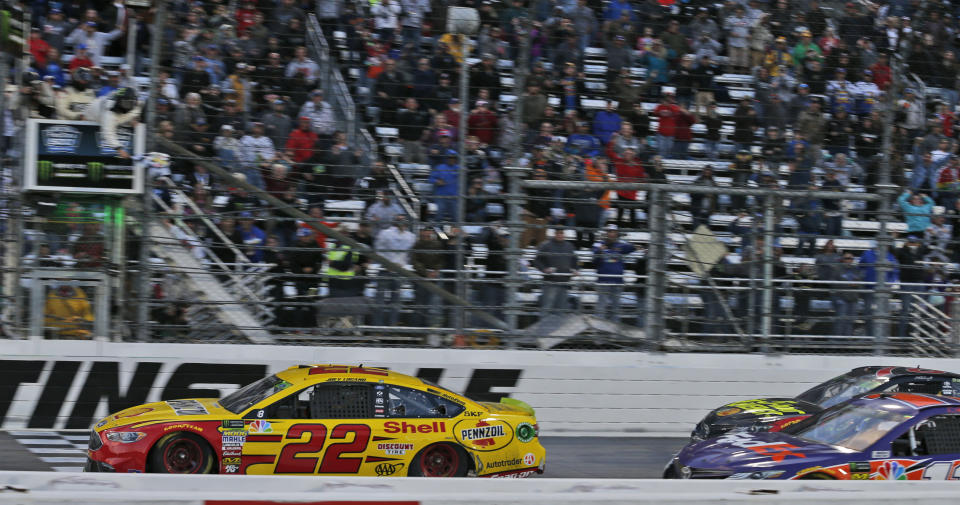 Joey Logano (22) crosses the finish line followed by Denny Hamlin (11) and Martin Trues Jr. (78) to win the Monster Energy NASCAR Cup Series auto race at Martinsville Speedway in Martinsville, Va., Sunday, Oct. 28, 2018. (AP Photo/Steve Helber)