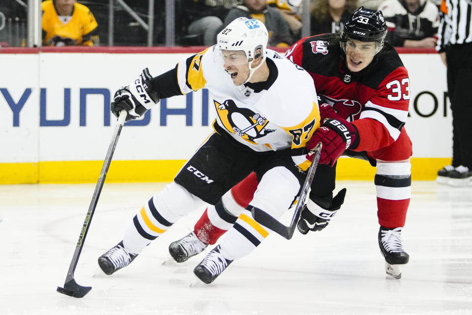 Pittsburgh Penguins' Sidney Crosby (87) drives past New Jersey Devils' Ryan Graves (33) during the first period of an NHL hockey game, Sunday, Jan. 22, 2023, in Newark, N.J. (AP Photo/Frank Franklin II)