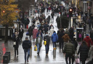 People walk along Buchanan Street in Glasgow, Scotland, Tuesday Nov. 17, 2020. 11 local authorities in Scotland, including Glasgow, are to be placed into its highest tier of coronavirus restrictions this week. The restrictions, which are similar to the lockdown in England, are set to run from Friday until Dec. 11. (Andrew Milligan/PA via AP)