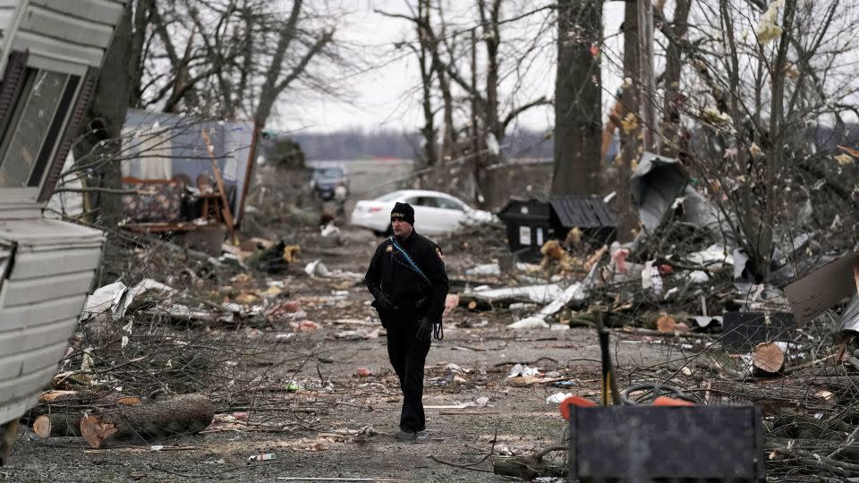 A Logan County sheriff walks down a road Friday following Thursday's severe storm, in Lakeview, Ohio. - Joshua A. Bickel/AP