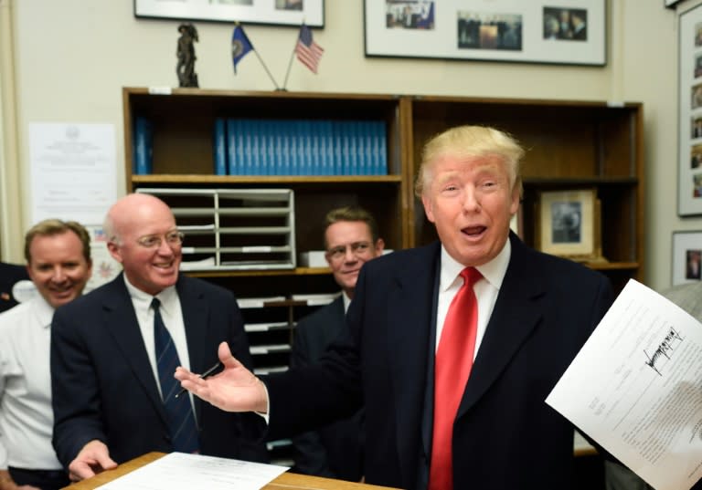 Republican presidential hopeful Donald Trump files for the New Hampshire state ballot as New Hampshire Secretary of State William Gardner (L) looks on, November 4, 2015 in Concord, New Hampshire