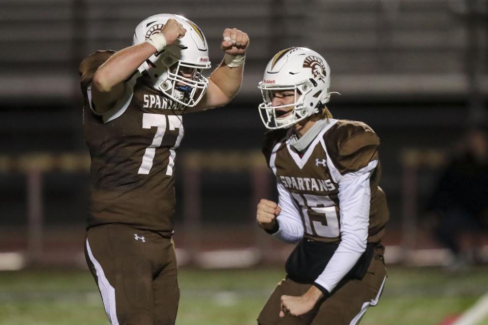 Roger Bacon kicker Dylan Rolfert (77) reacts with quarterback Logan Huber (15) after making the extra point in the second half against Preble Shawnee at Lakota West High School, Nov. 13, 2021.