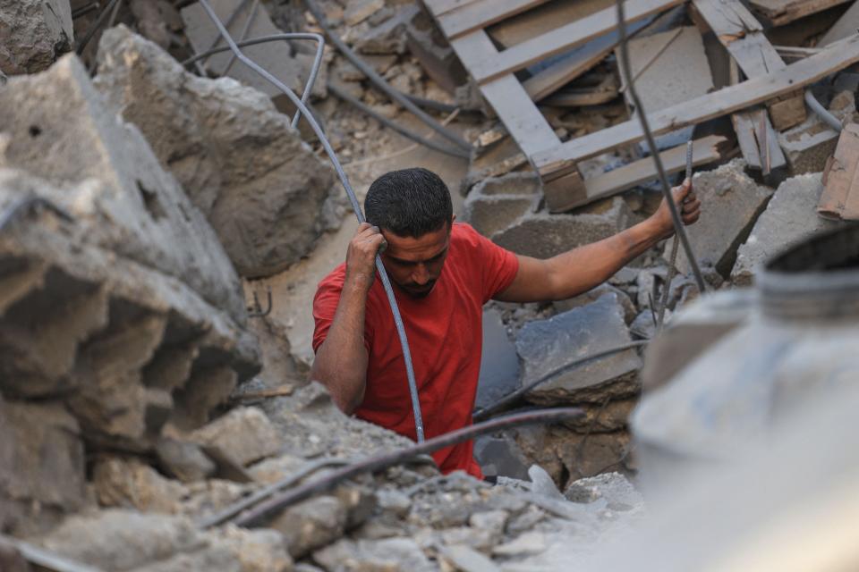 TOPSHOT - A Palestinian man looks for survivors in the rubble of a building following Israeli bombing in Rafah in the southern Gaza Strip, on October 31, 2023.