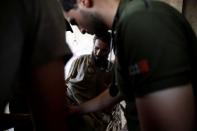 Medical workers attend to a displaced civilian shot by an ISIS State militant sniper, after he was rescued by Iraqi security forces from battle at Old City in western Mosul, Iraq June 23, 2017. REUTERS/Erik De Castro