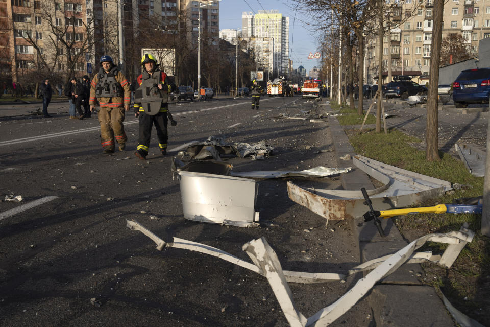 Firefighters pass by debris of a building following Russia's missile attack in Kyiv, Ukraine, Friday, Dec. 29, 2023. Russia launched about 110 missiles as well as drones against Ukrainian targets during the night Ukraine President Volodymyr Zelenskyy said Friday, in what appeared to be one of the biggest aerial barrages of the 22-month war.(AP Photo/Efrem Lukatsky)