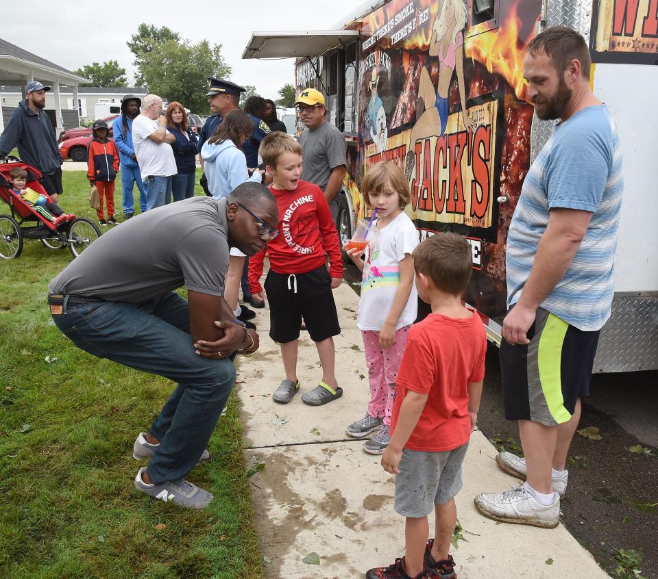 Michigan Lt. Governor Garlin Gilchrist talks with Jeremy Luke and his children, Jeremy Jr., 8, Emmi, 7, and Lincoln, 5. He asked them if their home was flooded or damaged at his visit to Frenchtown Villa. Dee and Terry Allin of Whiskey Jack's BBQ food truck heard about last night's storm damage at the park and drove to the park to give out free meals, which were paid for by Sun Communities.