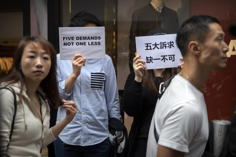 Protesters hold signs reading "Five Demands, Not One Less" during a rally in Hong Kong, Monday, Dec. 16, 2019. China's premier said Monday that turmoil over amendments to extradition legislation has damaged Hong Kong society on all fronts. (AP Photo/Mark Schiefelbein)