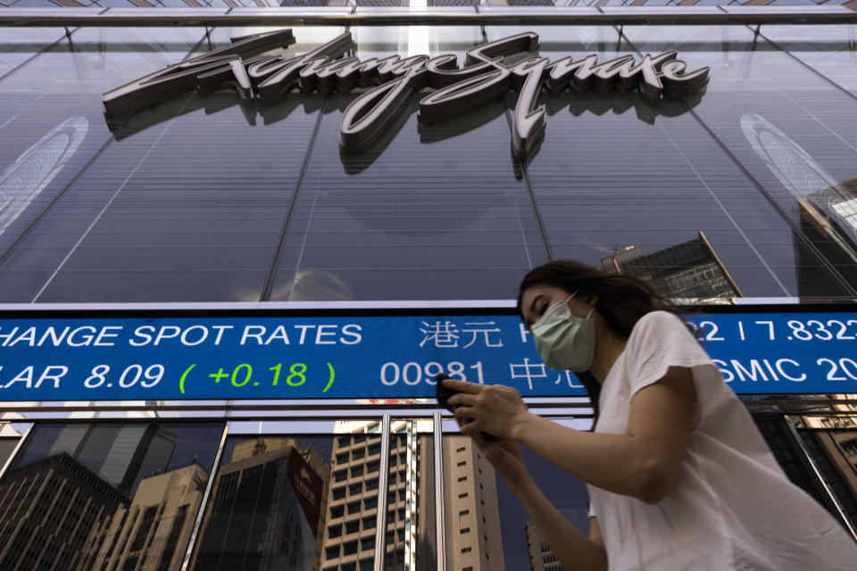 A pedestrian passes by the Hong Kong Stock Exchange electronic screen in Hong Kong, Friday, June 2, 2023. Asian stock markets followed Wall Street higher on Friday ahead of an update on the U.S. jobs market after Federal Reserve officials indicated they might skip another interest rate hike this month. (AP Photo/Louise Delmotte)