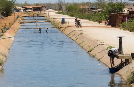 A resident collects water from an irrigation canal used to supply farms in Limoeiro do Norte, in Ceara state, January 15, 2015. REUTERS/Davi Pinheiro