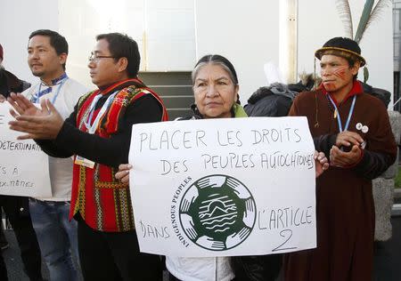 Indigenous observers demontrate, with a message that reads, "Include the rights of native peoples in Article 2" at the World Climate Change Conference 2015 (COP21) in Le Bourget, near Paris, France, December 9, 2015. REUTERS/Jacky Naegelen