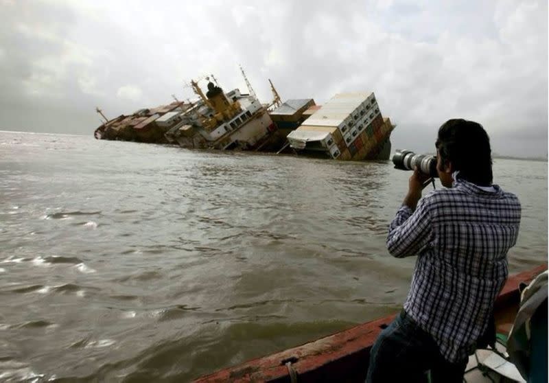 Reuters photographer Danish Siddiqui takes pictures from a fishing boat of the damaged cargo ship MSC Chitra in the Arabian Sea off the Mumbai coast