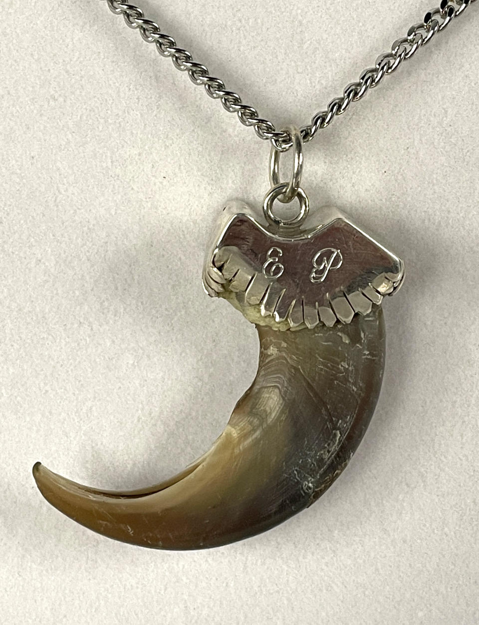 An Elvis Presley owned “E.P.” monogrammed grizzly bear claw necklace estimated to be worth $8,000 to $12,000. (©2022 rockhurstauctions.com)