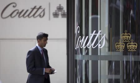 A man walks past the name of Coutts displayed on a branch of the bank in central London August 11, 2014. British lender Royal Bank of Scotland is considering selling the international arm of its private bank, Coutts, as it focuses more on domestic lending, it told staff on Monday. REUTERS/Neil Hall (BRITAIN - Tags: BUSINESS) - RTR41ZS6