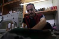 Zakaria Mosuli, the last tailor in Aleppo's battered Old City, sews military headwear at his shop