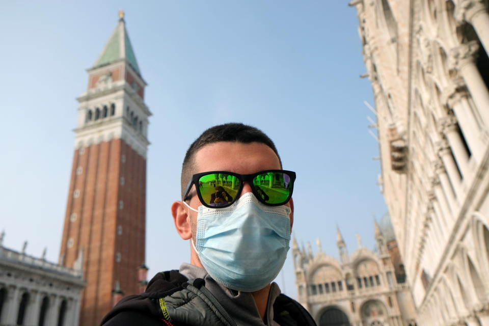 A man wears a protective face mask in St. Mark's Square after the last days of Venice Carnival were cancelled due to coronavirus, in Venice, Italy February 24, 2020. REUTERS/Manuel Silvestri