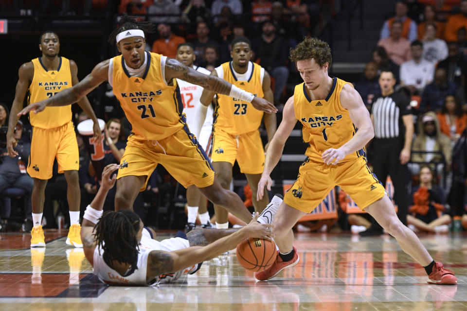 UMKC's RayQuawndis Mitchell (21) defends as the ball comes loose after a tie-up between teammate Sam Martin (1) and Illinois' Skyy Clark during the second half of an NCAA college basketball game Friday, Nov. 11, 2022, in Champaign, Ill. (AP Photo/Michael Allio)