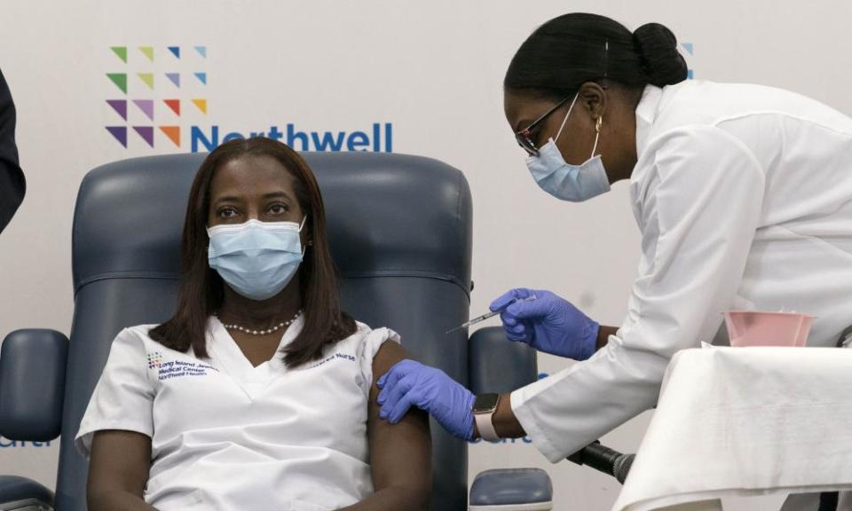 Sandra Lindsay, left, receives the Covid vaccine from Dr Michelle Chester, right, in Queens, New York, inDecember.