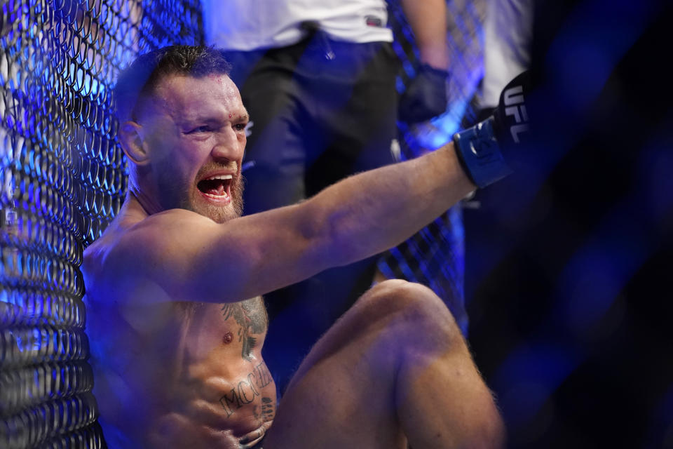 Conor McGregor yells as he sits on the mat after an injury during his lightweight mixed martial arts bout with Dustin Poirier at UFC 264 on Saturday, July 10, 2021, in Las Vegas. (AP Photo/John Locher)