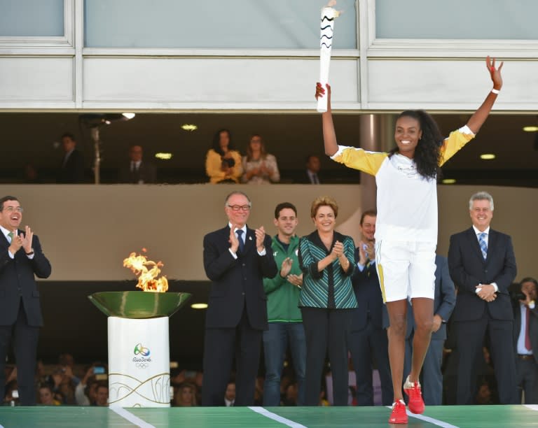 Brazilian volleyball player Fabiana Claudino holds the Olympic torch following the flame's arrival in Brasilia on May 3, 2016