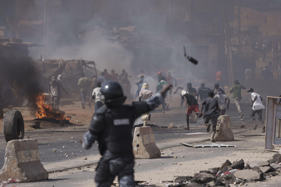 A riot police throws a tear gas canister at demonstrators during a protest at a neighbourhood in Dakar, Senegal, Friday, June 2, 2023. Clashes between police and supporters of Senegalese opposition leader Ousmane Sonko left nine people dead, the government said Friday, with authorities issuing a blanket ban on the use of several social media platforms in the aftermath of the violence. (AP Photo/Leo Correa)
