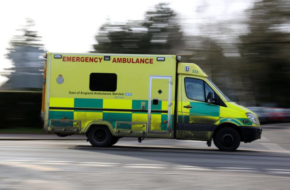 An East of England Ambulance is driven along the road in Cambridge (PA)