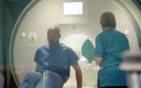 Alan Shearer exiting an MRI scanner at the Queen Elizabeth University Hospital.