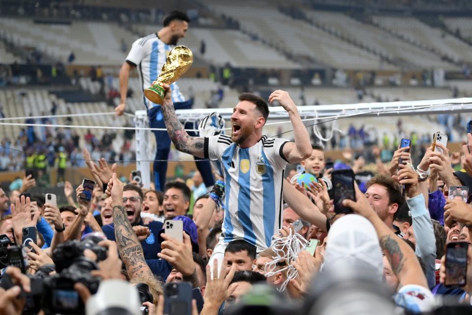 Lionel Messi of Argentina celebrates with teammates and the FIFA World Cup Qatar 2022 Winner’s Trophy after the team’s victory during the FIFA World Cup (Getty Images)