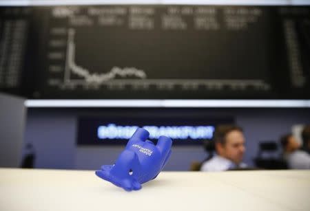 A styrofoam bull figure lies on its side on a counter in front of the German share price index DAX board at Frankfurt's stock exchange in Frankfurt, Germany January 7, 2016. REUTERS/Kai Pfaffenbach