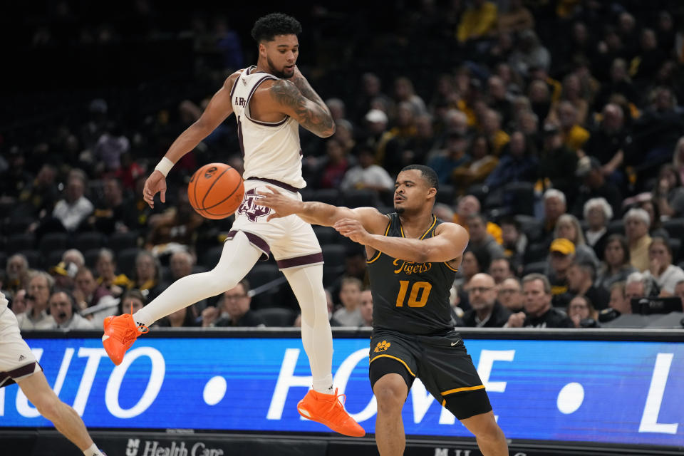 Missouri's Nick Honor (10) passes around Texas A&M's Jace Carter during the first half of an NCAA college basketball game Wednesday, Feb. 7, 2024, in Columbia, Mo. (AP Photo/Jeff Roberson)