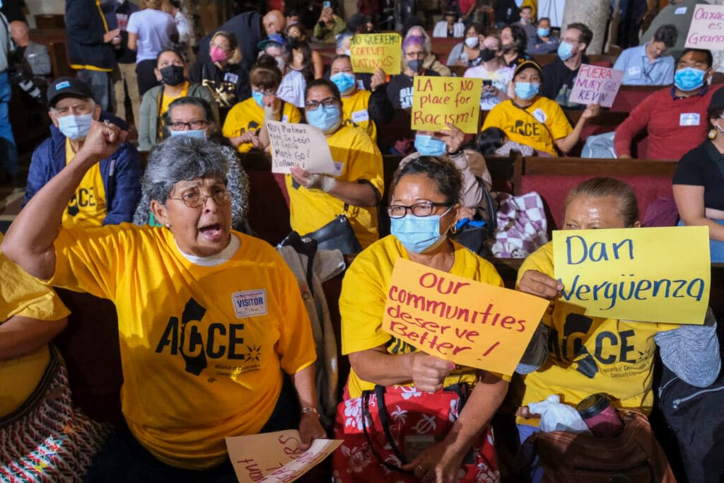 People hold signs and shout slogans before the starting the Los Angeles City Council meeting on Tuesday, Oct. 11, 2022 in Los Angeles. (AP Photo/Ringo H.W. Chiu, File)