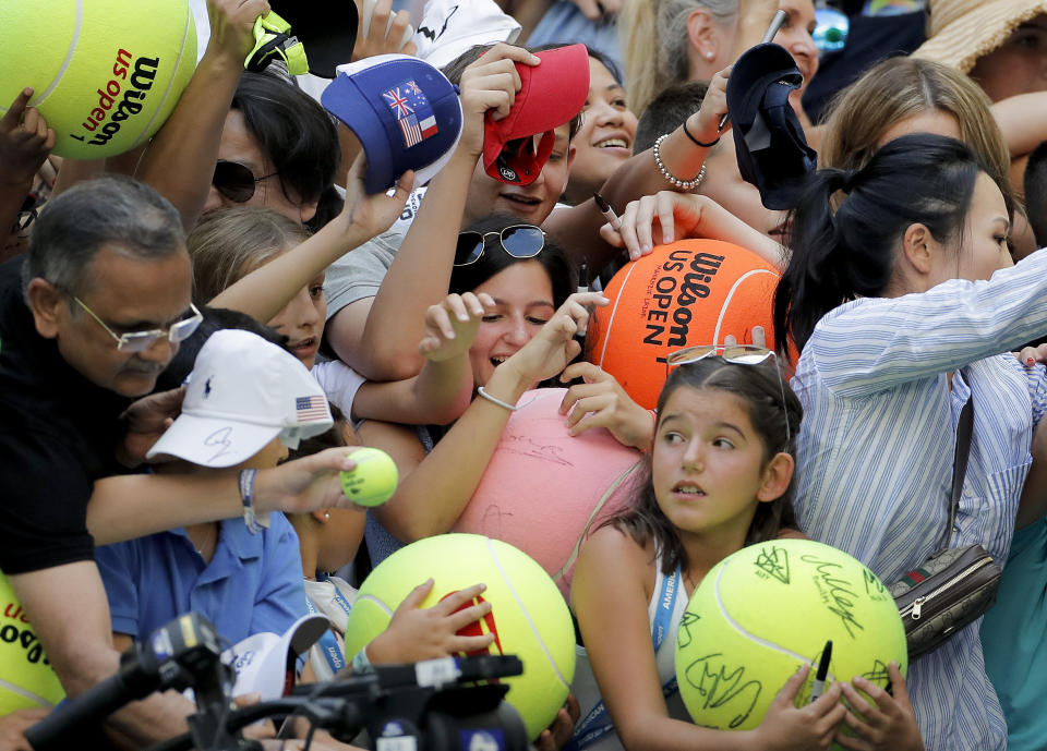 FILE - In this Aug. 31, 2019, file photo, tennis fans crowd the edge of the court hoping for an autograph from Rafael Nadal, of Spain, during round three of the U.S. Open tennis championships in New York. The U.S. Tennis Association intends to hold the U.S. Open Grand Slam tournament in New York starting in August without spectators, if it gets governmental support -- and a formal announcement could come this week. (AP Photo/Eduardo Munoz Alvarez, File)