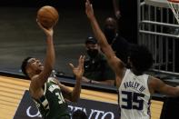 Milwaukee Bucks' Giannis Antetokounmpo shoots past Sacramento Kings' Marvin Bagley III during the first half of an NBA basketball game Sunday, Feb. 21, 2021, in Milwaukee. (AP Photo/Morry Gash)