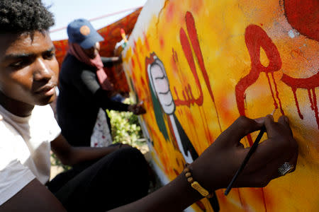 FILE PHOTO: Artists work on a graffiti on a wall near the defence ministry compound in Khartoum, Sudan, April 24, 2019. REUTERS/Umit Bektas/File Photo