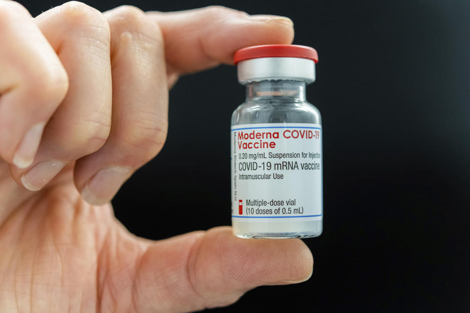 A person shows an ampoule Moderna vaccine against the COVID-19 disease, at the Diakonie Hospital "DIAKO" vaccination ward in Bremen, Germany, Friday, Jan. 15, 2021. Besides the Pfizer/BioNTech vaccine, Moderna is the second corona vaccine approved in the European Union. (Mohssen Assanimoghaddam/dpa via AP)