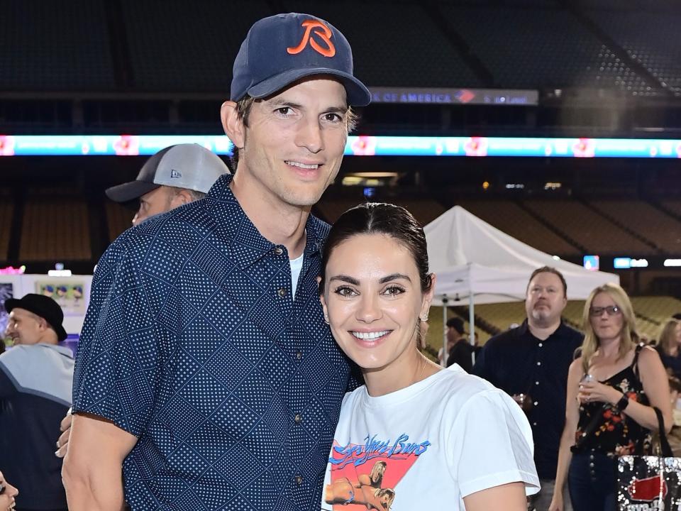 ashton kutcher and mila kunis posing for a photo at a dogers game in august 2022