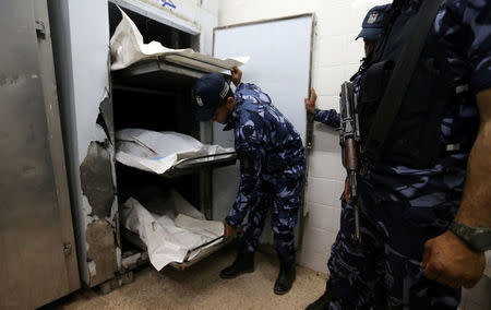 ATTENTION - VISUAL COVERAGE OF SCENES OF INJURY OR DEATH Palestinian Hamas police officers stand next to the bodies of Hamas gunmen, who were killed in an explosion, at a hospital morgue in the central Gaza Strip May 5, 2018. REUTERS/Ibraheem Abu Mustafa