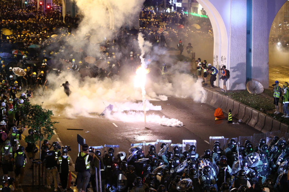 Protesters are engulfed by teargas during a confrontation with riot police in Hong Kong Sunday, July 21, 2019. Hong Kong police launched tear gas at protesters Sunday after a massive pro-democracy march continued late into the evening. The action was the latest confrontation between police and demonstrators who have taken to the streets to protest an extradition bill and call for electoral reforms in the Chinese territory. (Lo Kwanho/HK01 via AP)